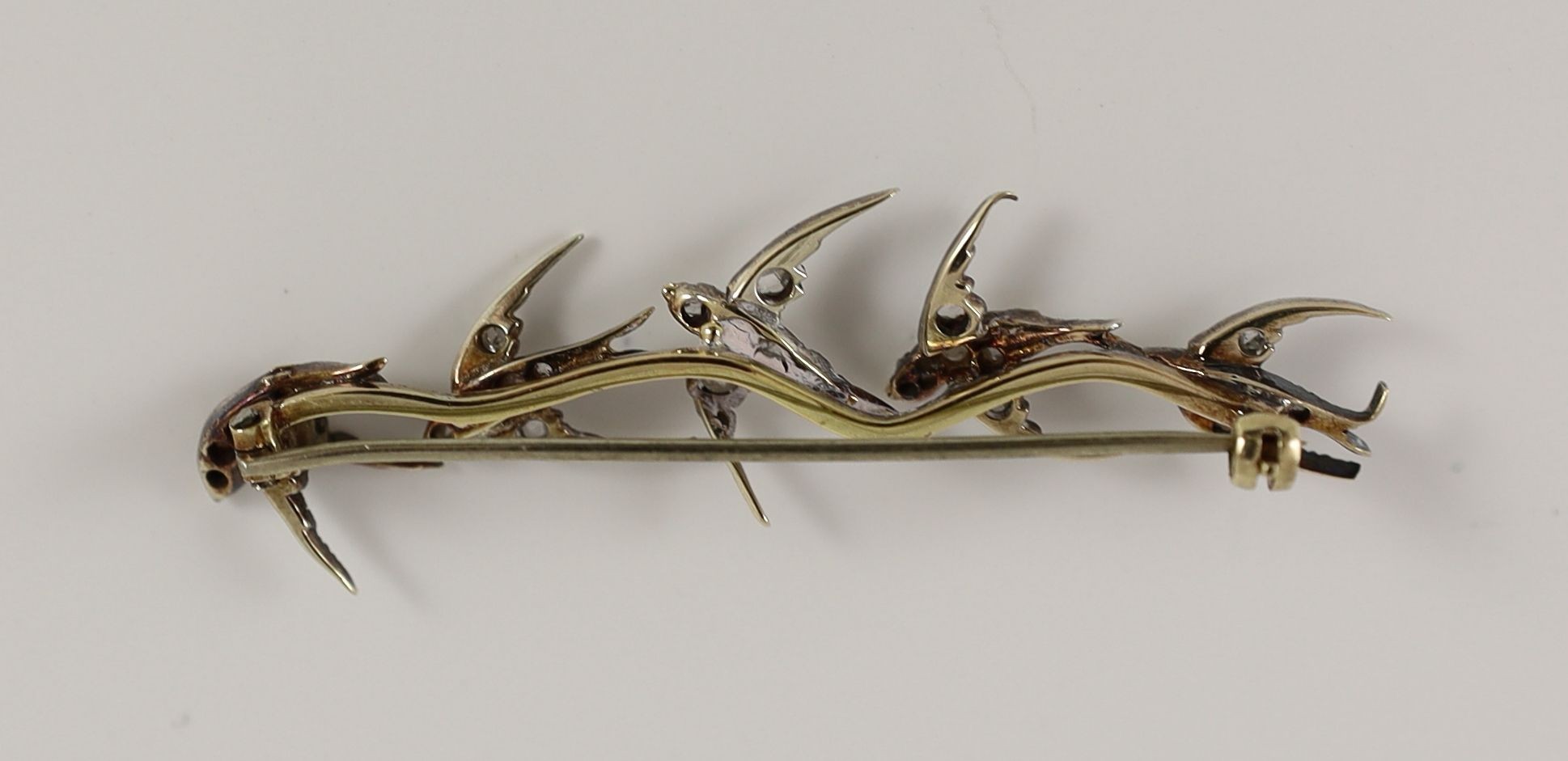 A late Victorian gold and rose cut diamond set brooch, modelled as five swallows in flight